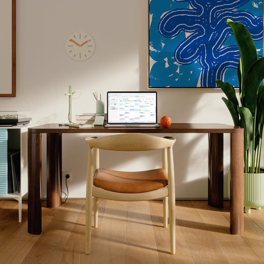 A laptop on a desk showing the Outlook calendar.